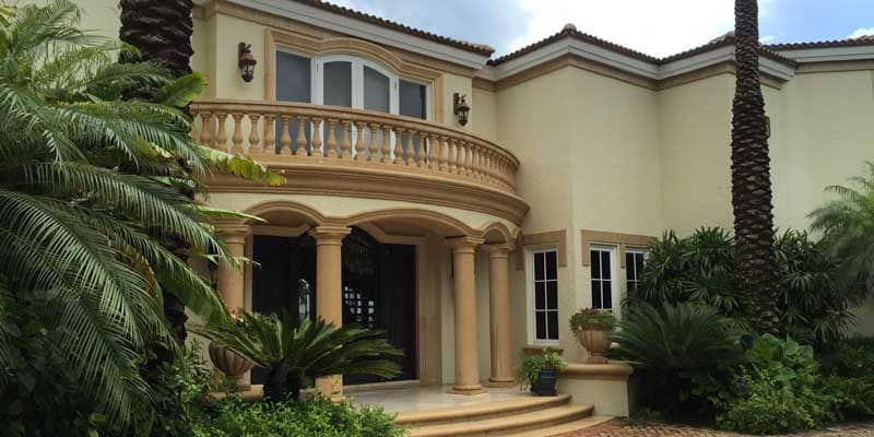 A large house with a balcony and columns.